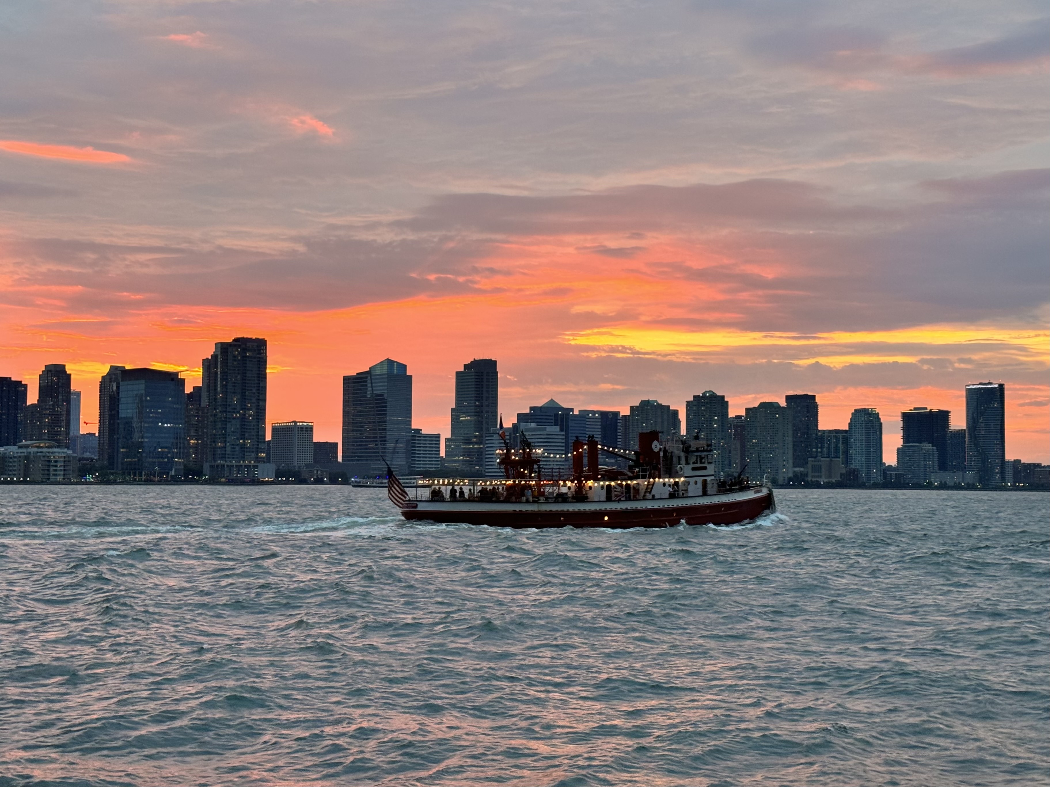 Orange sunset over the water and a waterfront skyline